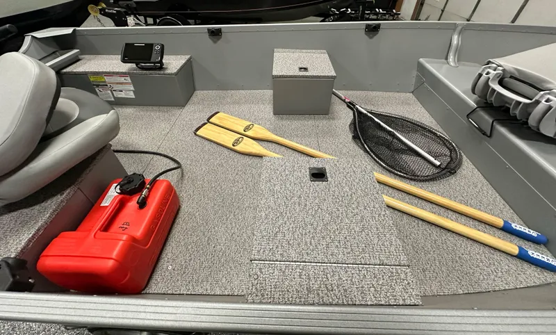 Slide: The Image of 2023 Alumacraft V14 boat interior with paddles, net, and red fuel tank. - 14