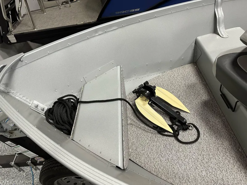 Slide: The Image of 2023 Alumacraft V14 boat interior with rope and anchor on carpeted floor. - 9