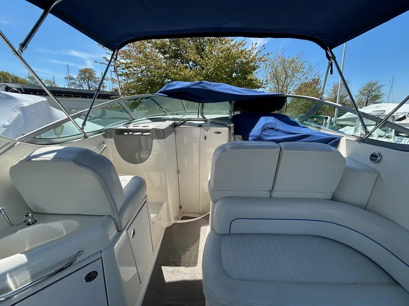 Slide: The Image of 2007 Bayliner 305 boat interior with white seating and blue canopy. - 11