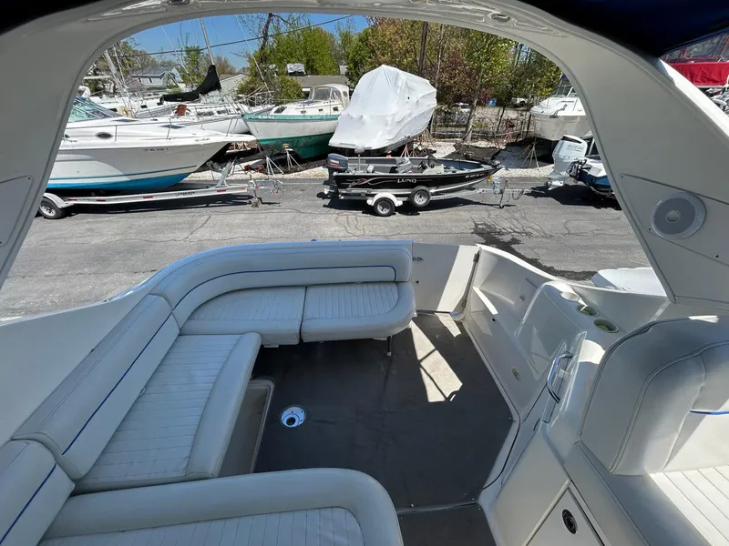 Slide: The Image of 2007 Bayliner 305 boat interior with white seating, docked among other boats. - 14