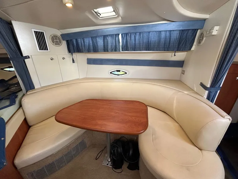 Slide: The Image of 2007 Bayliner 305 interior with beige seating and wooden table. - 21