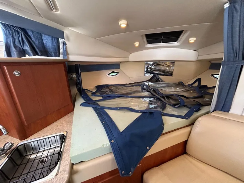 Slide: The Image of 2007 Bayliner 305 cabin interior with bed, sink, and storage. - 22