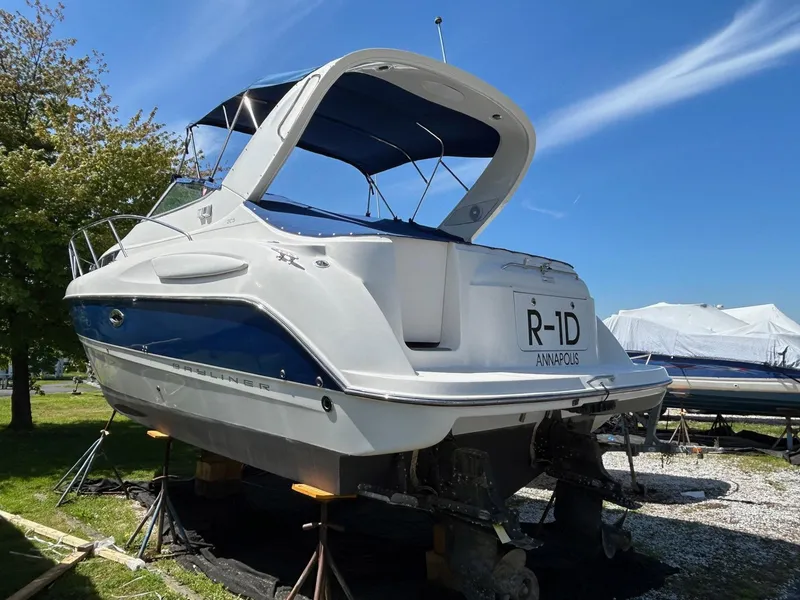 Slide: The Image of 2007 Bayliner 305 boat on stands, blue and white, sunny day, Annapolis. - 3