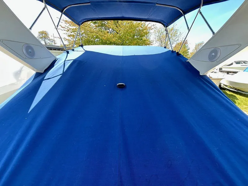 Slide: The Image of 2007 Bayliner 305 boat with blue cover and canopy, docked outdoors. - 5