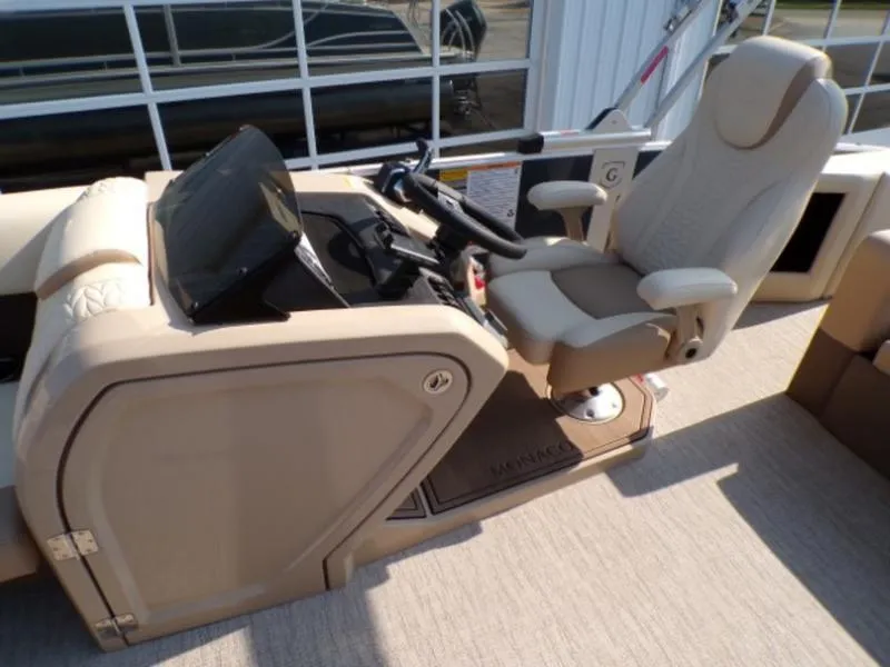 Slide: The Image of 2025 Godfrey Monaco 255 DFL boat helm with beige captain's chair and control panel. - 12