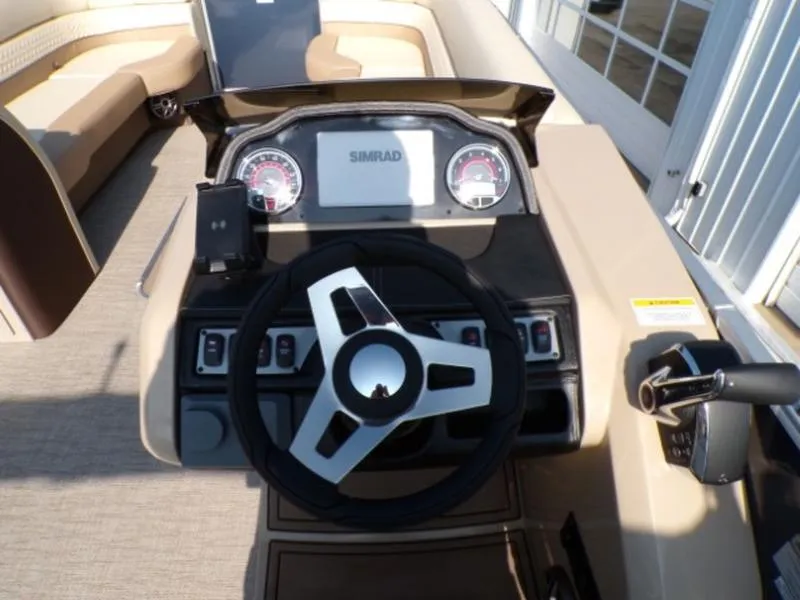 Slide: The Image of 2025 Godfrey Monaco 255 DFL boat dashboard with steering wheel and control panel. - 14