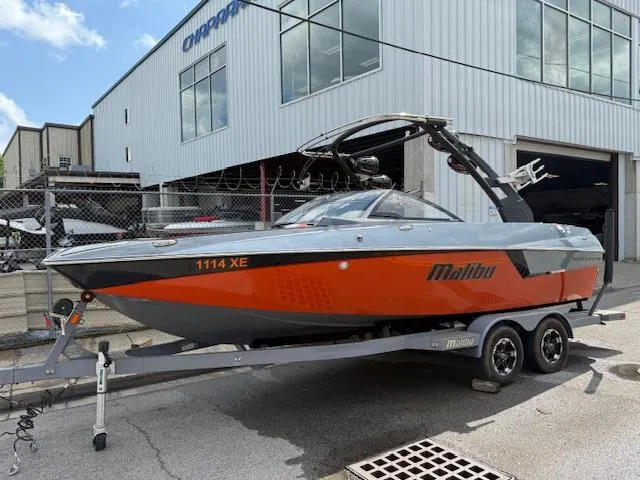 Slide: The Image of 2019 Malibu Wakesetter 22 MXZ boat on trailer, parked outside a building. - 0