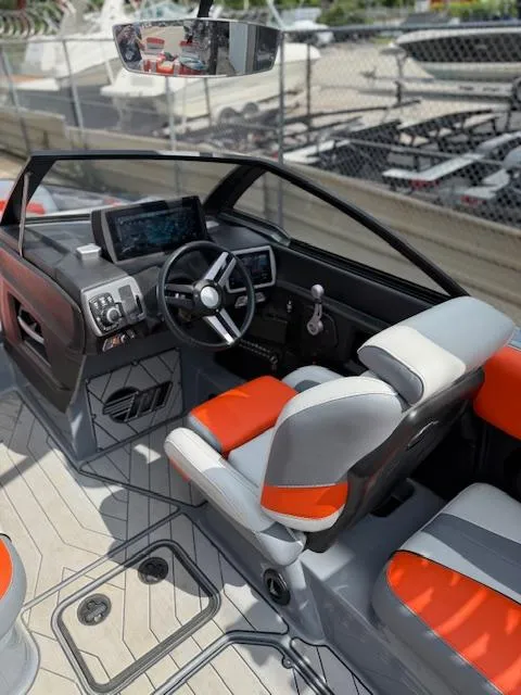 Slide: The Image of 2019 Malibu Wakesetter 22 MXZ boat interior with modern dashboard and orange-accented seating. - 12