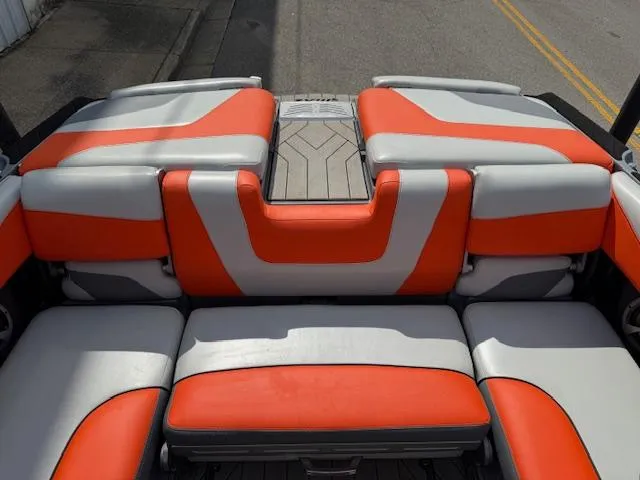 Slide: The Image of 2019 Malibu Wakesetter 22 MXZ boat interior with orange and gray seating. - 18