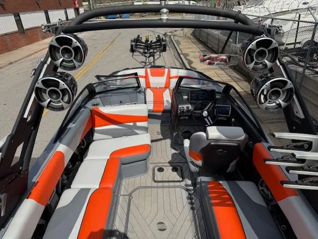 Slide: The Image of 2019 Malibu Wakesetter 22 MXZ interior with orange and gray seating, advanced sound system. - 21