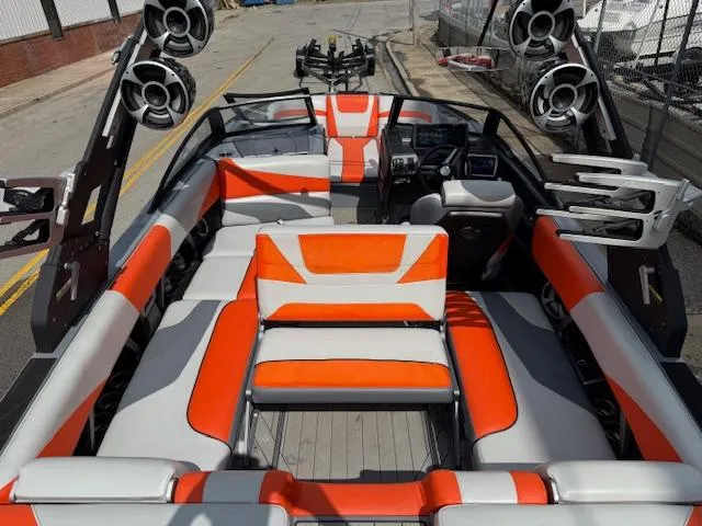 Slide: The Image of 2019 Malibu Wakesetter 22 MXZ interior with orange and white seating, featuring advanced audio system. - 25