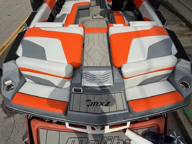 Slide: The Image of 2019 Malibu Wakesetter 22 MXZ boat interior with orange and gray seating. - 28