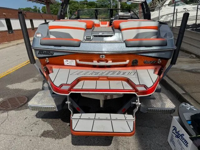 Slide: The Image of 2019 Malibu Wakesetter 22 MXZ boat with orange and gray seating, rear view. - 29