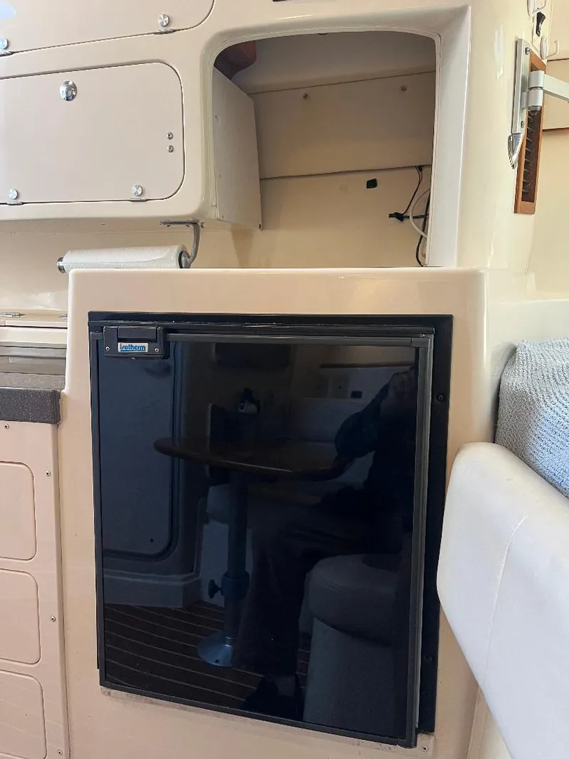 Slide: The Image of 2003 Grady-White 33 Express cabin interior with storage and mini fridge. - 11