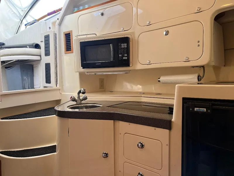 Slide: The Image of 2003 Grady-White 33 Express boat interior with kitchenette, microwave, and storage cabinets. - 12