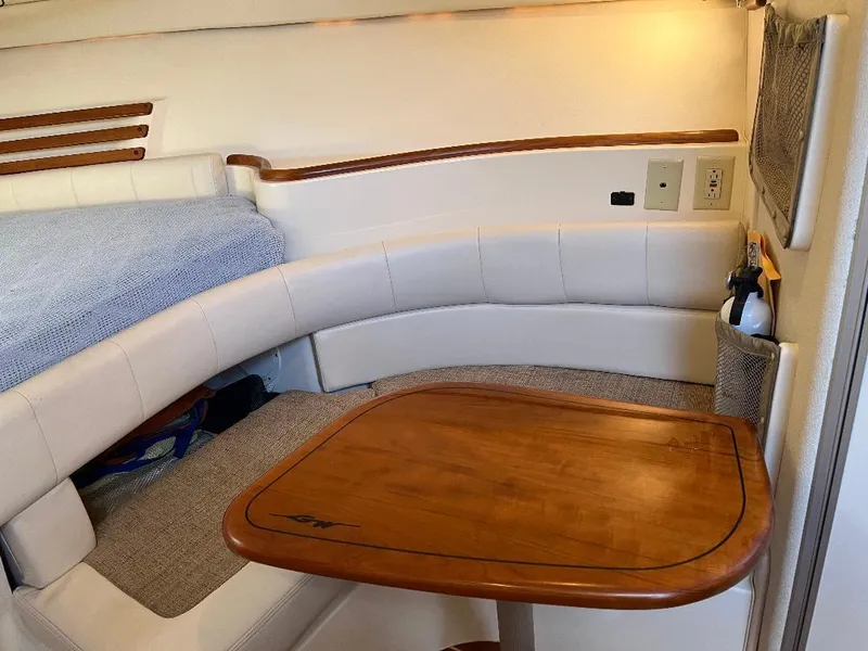 Slide: The Image of 2003 Grady-White 33 Express cabin interior with wooden table and cushioned seating. - 13