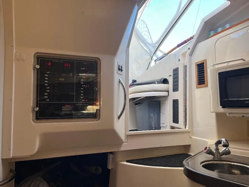 Slide: The Image of 2003 Grady-White 33 Express cabin interior with control panel, sink, and microwave. - 16