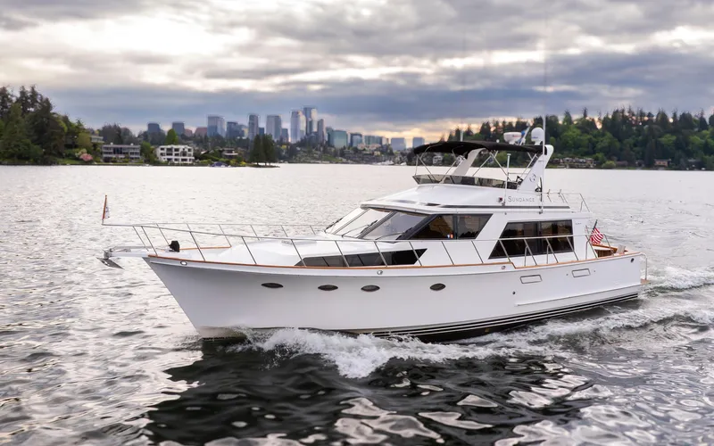 Slide: The Image of 1989 Ocean Alexander 50 Sedan cruising on a scenic lake with city skyline backdrop. - 0