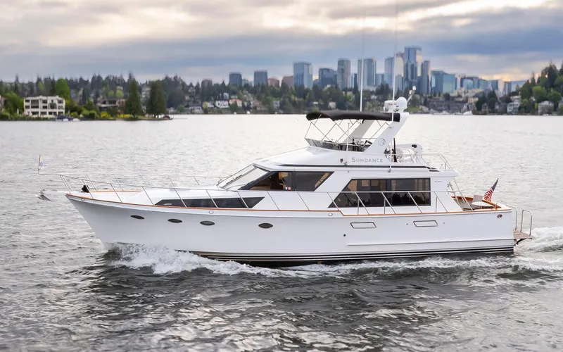 Slide: The Image of 1989 Ocean Alexander 50 Sedan yacht cruising on water with city skyline in background. - 1