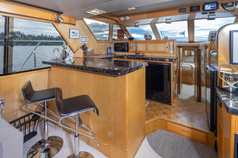 Slide: The Image of Interior of 1989 Ocean Alexander 50 Sedan yacht with modern kitchen and bar seating. - 12