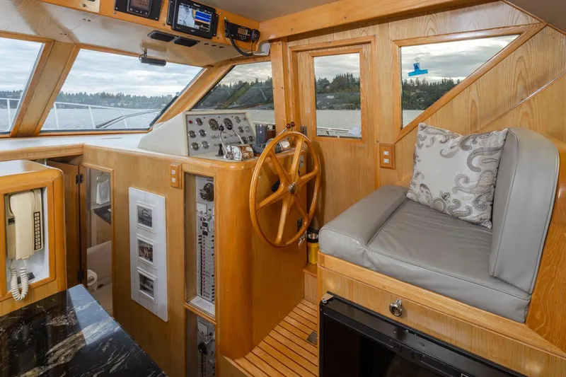 Slide: The Image of 1989 Ocean Alexander 50 Sedan interior with wooden helm, steering wheel, and cushioned seating. - 15