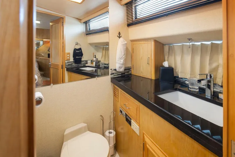 Slide: The Image of Bathroom interior of 1989 Ocean Alexander 50 Sedan yacht, featuring modern fixtures and wood cabinetry. - 23