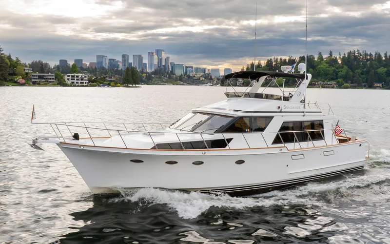 Slide: The Image of 1989 Ocean Alexander 50 Sedan yacht cruising on a scenic lake with city skyline backdrop. - 3