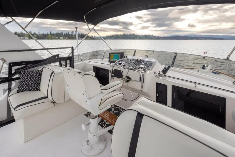 Slide: The Image of 1989 Ocean Alexander 50 Sedan yacht interior with steering wheel and seating, on a calm lake. - 33