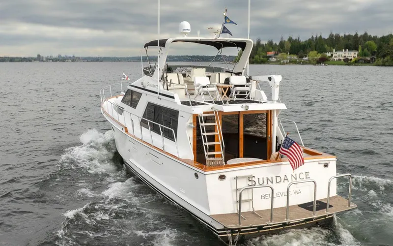 Slide: The Image of 1989 Ocean Alexander 50 Sedan yacht cruising on a lake, displaying an American flag. - 6