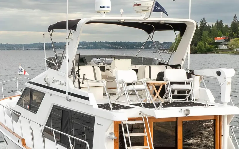 Slide: The Image of 1989 Ocean Alexander 50 Sedan yacht on a serene lake with lush green shoreline. - 7