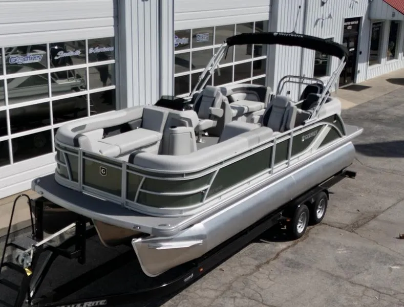 Slide: The Image of 2025 Godfrey SWEETWATER 2286 SB pontoon boat on trailer, parked outside dealership. - 1
