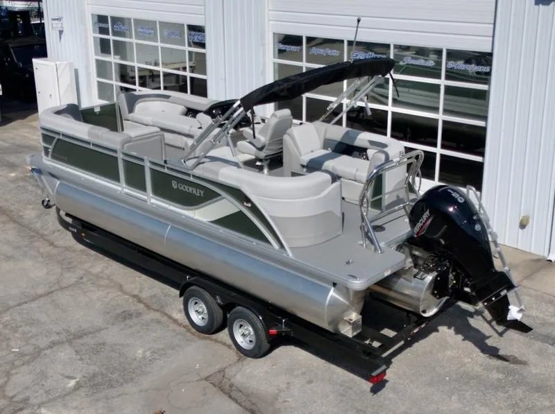 Slide: The Image of 2025 Godfrey SWEETWATER 2286 SB pontoon boat with trailer, parked outside a garage. - 5