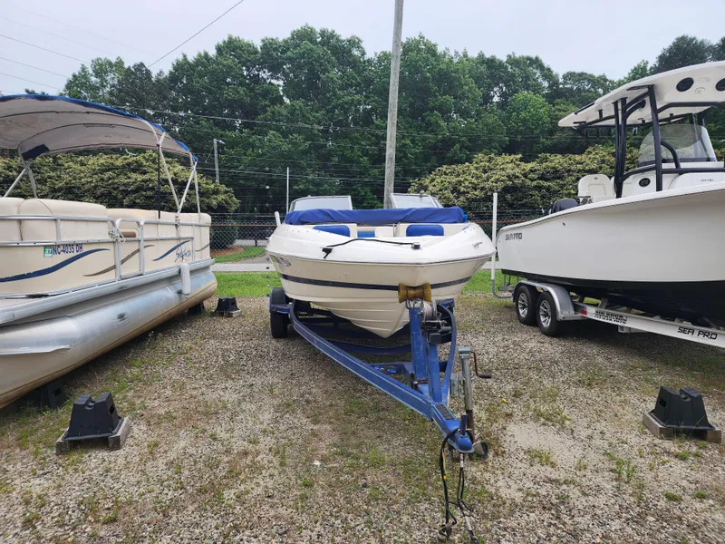 Slide: The Image of 2003 Mariah Bow Rider SX9 boat on trailer, parked between two other boats. - 3