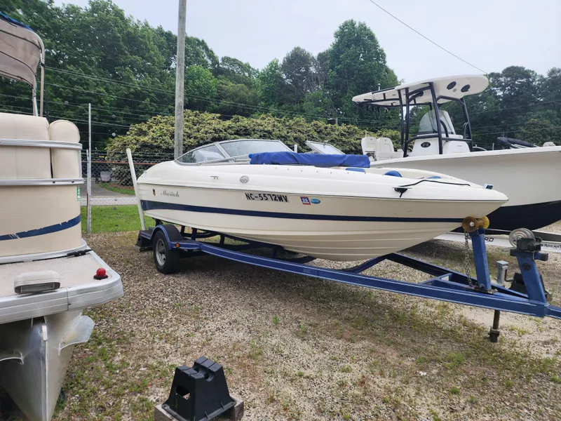 Slide: The Image of 2003 Mariah Bow Rider SX9 on trailer, parked outdoors near other boats. - 5