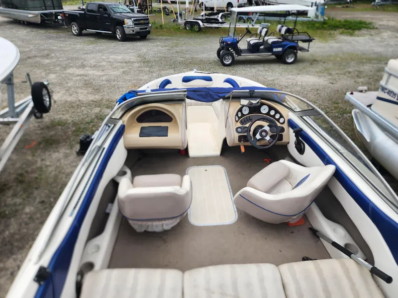 Slide: The Image of 2003 Mariah Bow Rider SX9 interior with steering wheel, seating, and dashboard in a boatyard. - 6