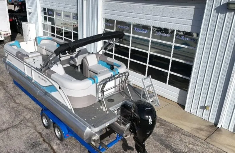 Slide: The Image of 2025 Godfrey Sweetwater 2286 SB pontoon boat on trailer, parked outside a garage. - 3