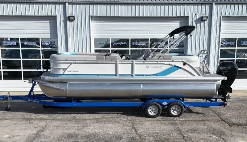 Slide: The Image of 2025 Godfrey Sweetwater 2286 SB pontoon boat on trailer, parked outside a garage. - 6