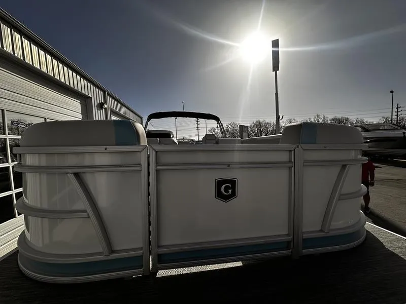 Slide: The Image of 2025 Godfrey Sweetwater 2286 SB pontoon boat under bright sun at dealership. - 8