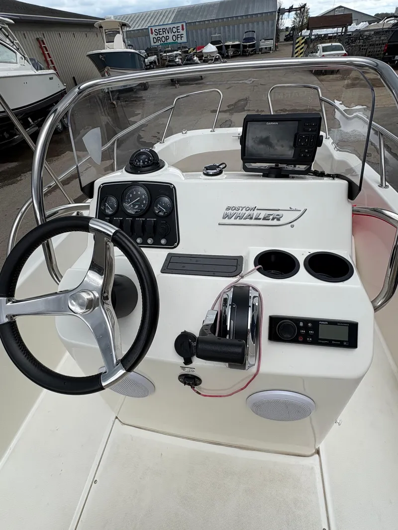 Slide: The Image of 2019 Boston Whaler 170 Dauntless boat console with steering wheel and navigation equipment. - 10