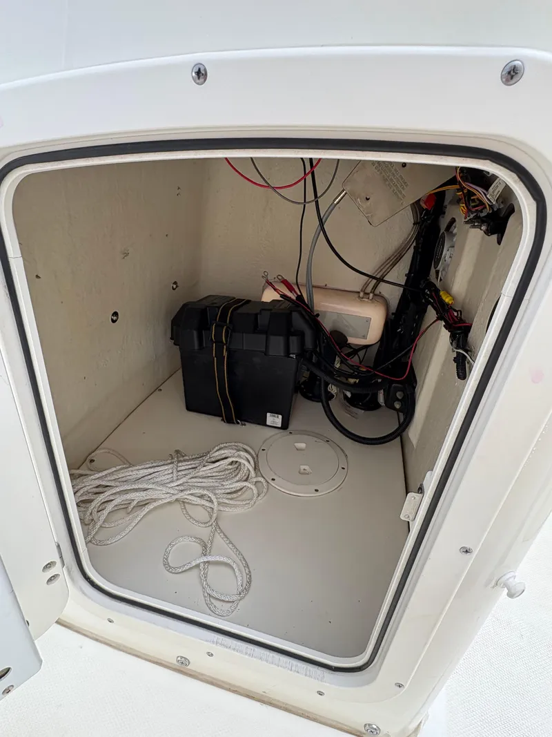 Slide: The Image of Storage compartment of 2019 Boston Whaler 170 Dauntless with battery and rope. - 11