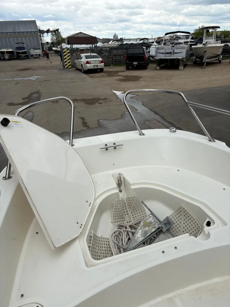 Slide: The Image of 2019 Boston Whaler 170 Dauntless boat with open storage compartment at a marina. - 15