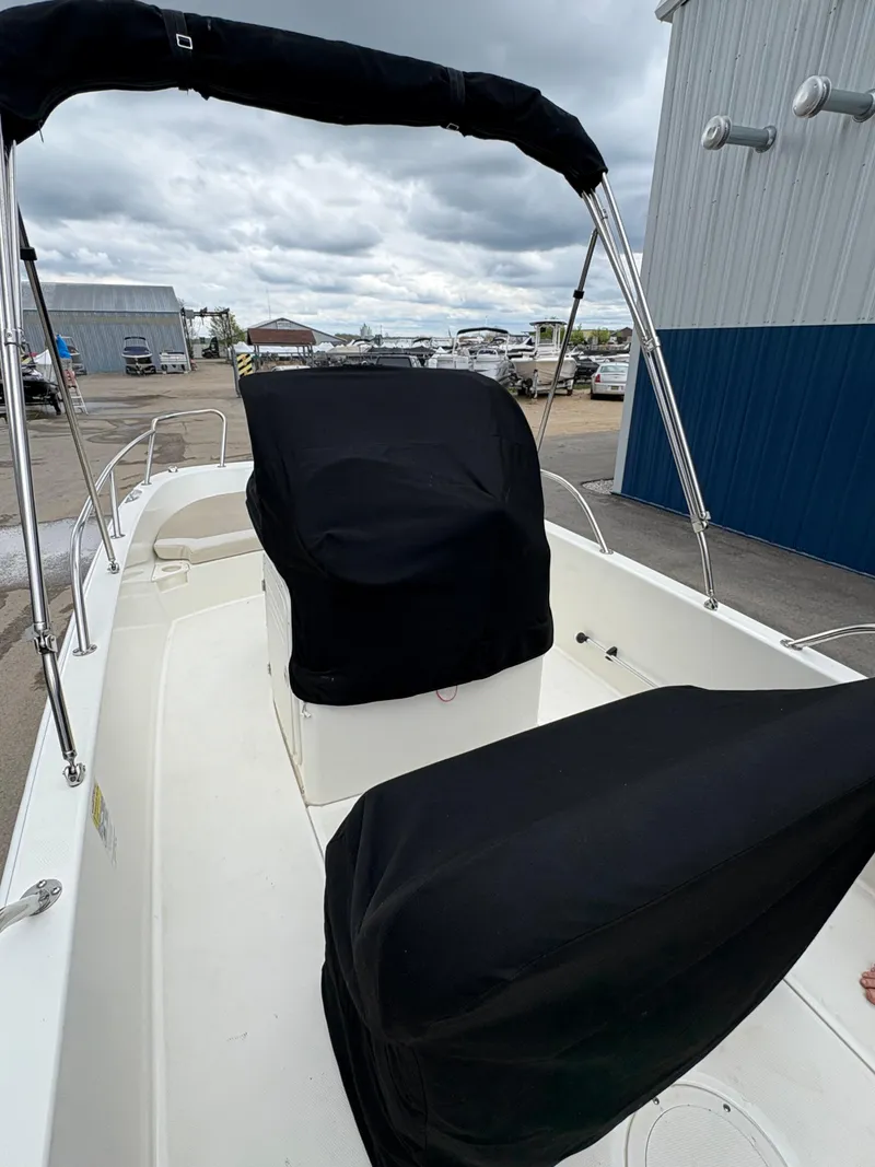 Slide: The Image of 2019 Boston Whaler 170 Dauntless boat with black covers, docked at marina. - 17