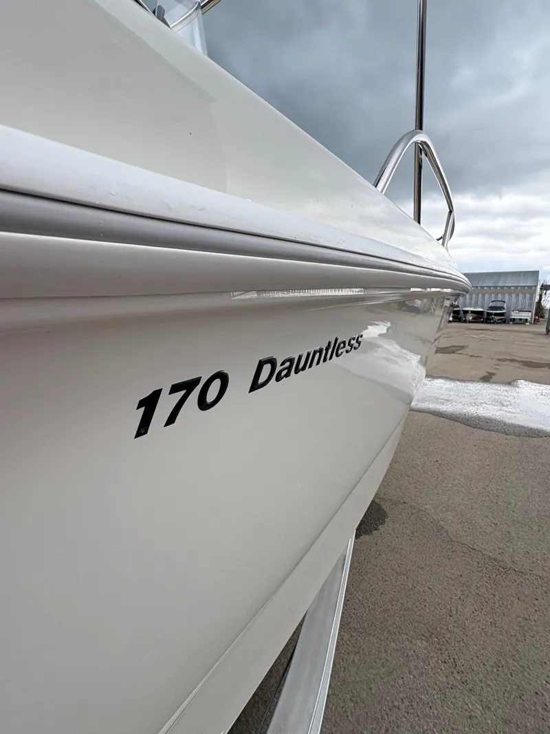 Slide: The Image of 2019 Boston Whaler 170 Dauntless boat side view with cloudy sky background. - 4