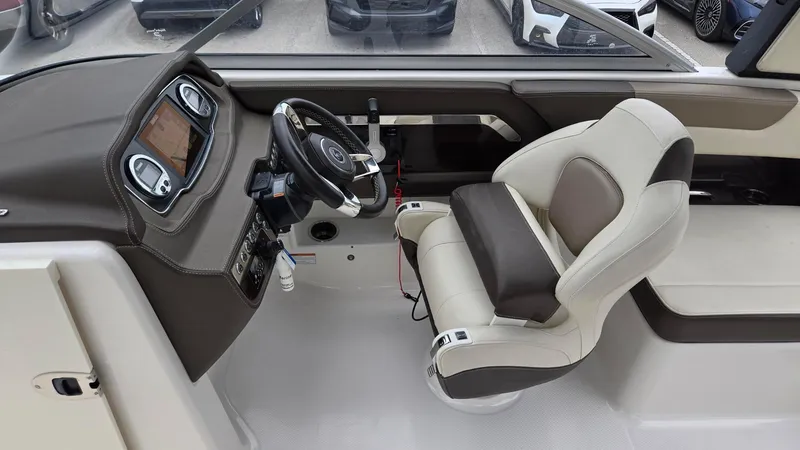 Slide: The Image of 2021 Chaparral 230 boat interior with steering wheel and captain's seat. - 11