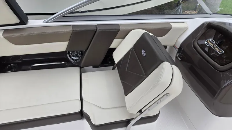 Slide: The Image of Interior seating of 2021 Chaparral 230 boat, featuring stylish brown and white upholstery. - 12
