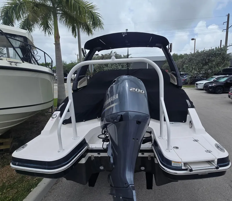 Slide: The Image of 2021 Chaparral 230 boat with Yamaha 200 engine, parked near palm trees. - 15