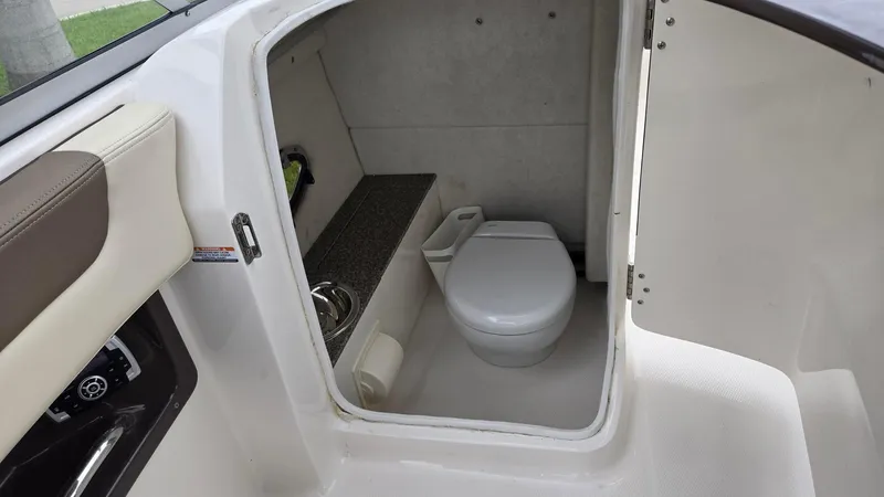 Slide: The Image of 2021 Chaparral 230 boat interior with compact bathroom and toilet. - 8