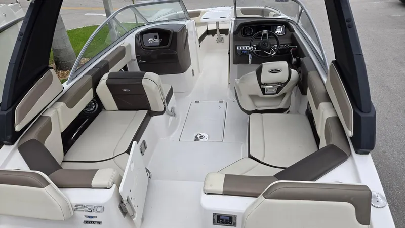 Slide: The Image of 2021 Chaparral 230 boat interior with beige seating and modern dashboard. - 9