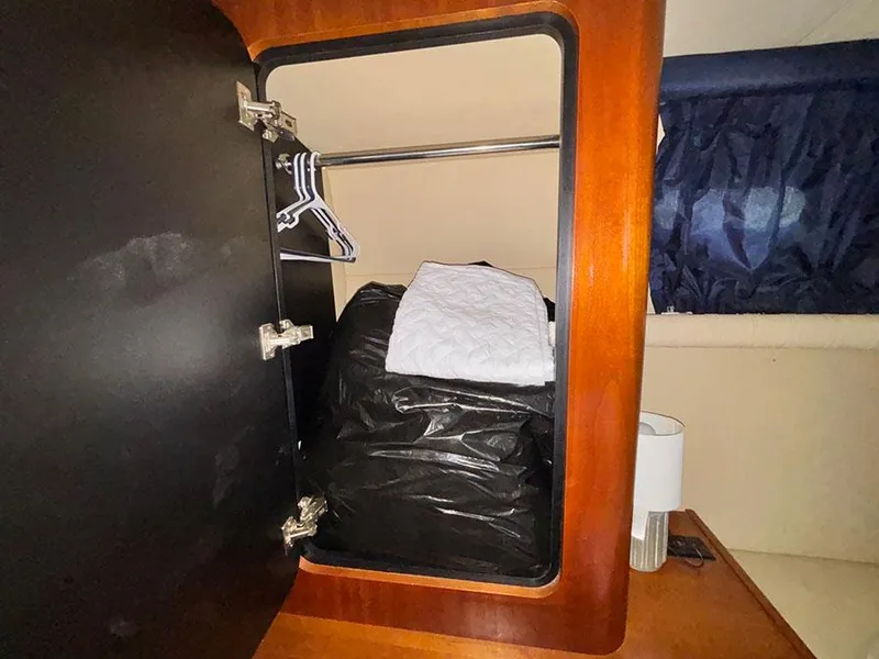 Slide: The Image of 2004 Cruisers Yachts 375 Motoryacht closet with hangers and storage bag. - 17