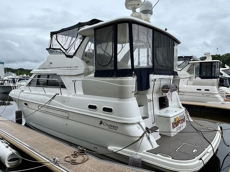 Slide: The Image of 2004 Cruisers Yachts 375 Motoryacht docked, featuring sleek design and spacious upper deck. - 2